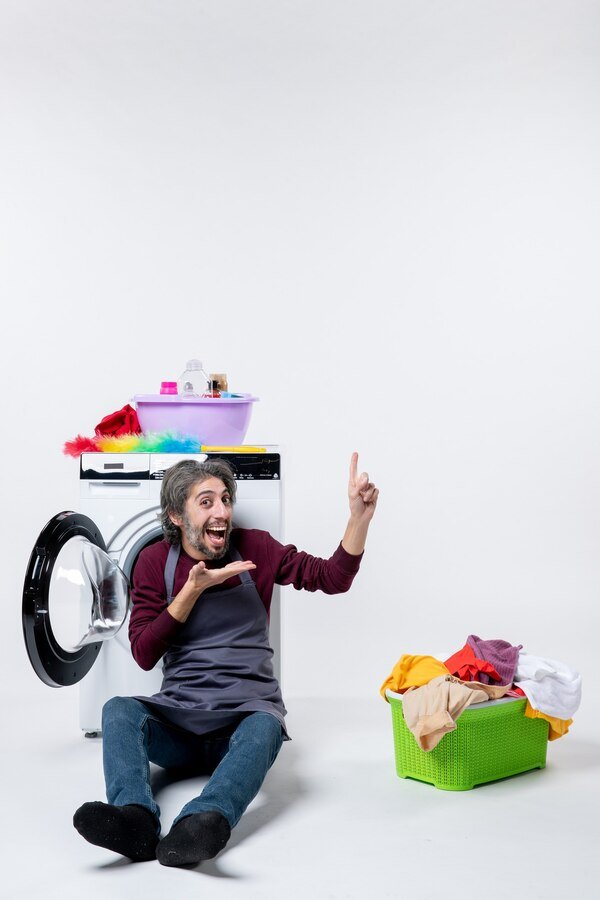 man sitting in front of laundry machine